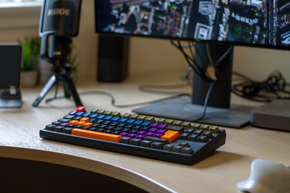 black corded computer keyboard below turned-on flat screen monitor