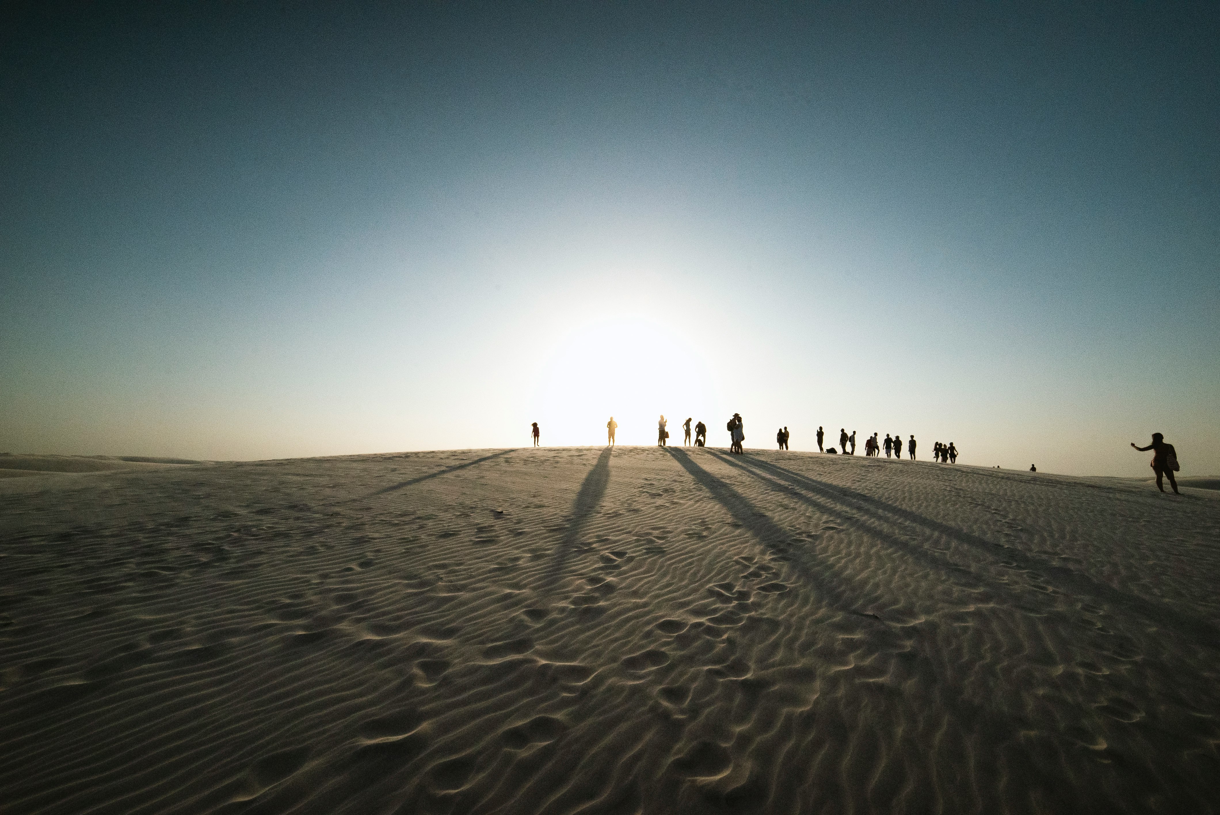 people on desert under blue sky