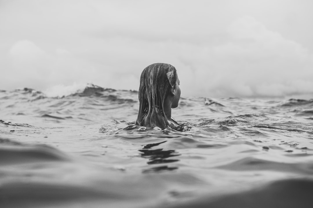 grayscale photography of woman in water during daytime