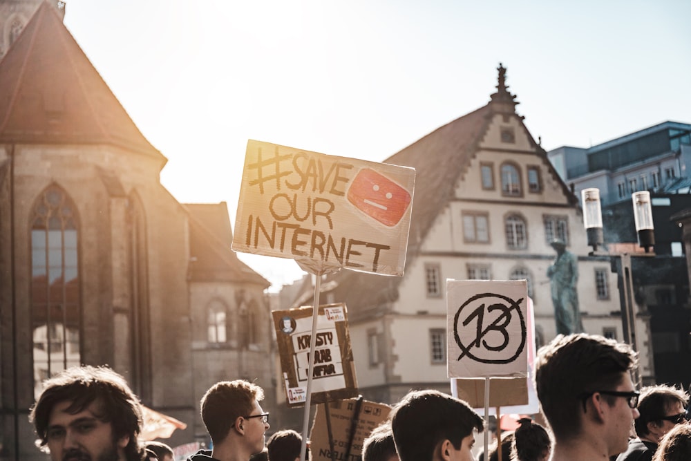 Persona que sostiene la señalización de Save Our Internet durante el día