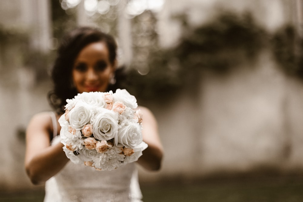 femme tenant un bouquet de fleurs