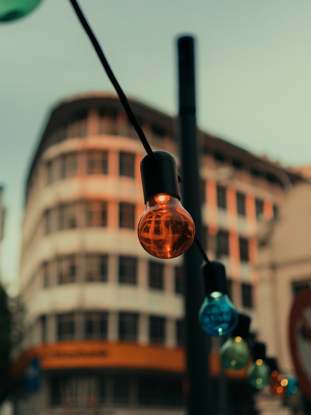 a close up of a street light with a building in the background