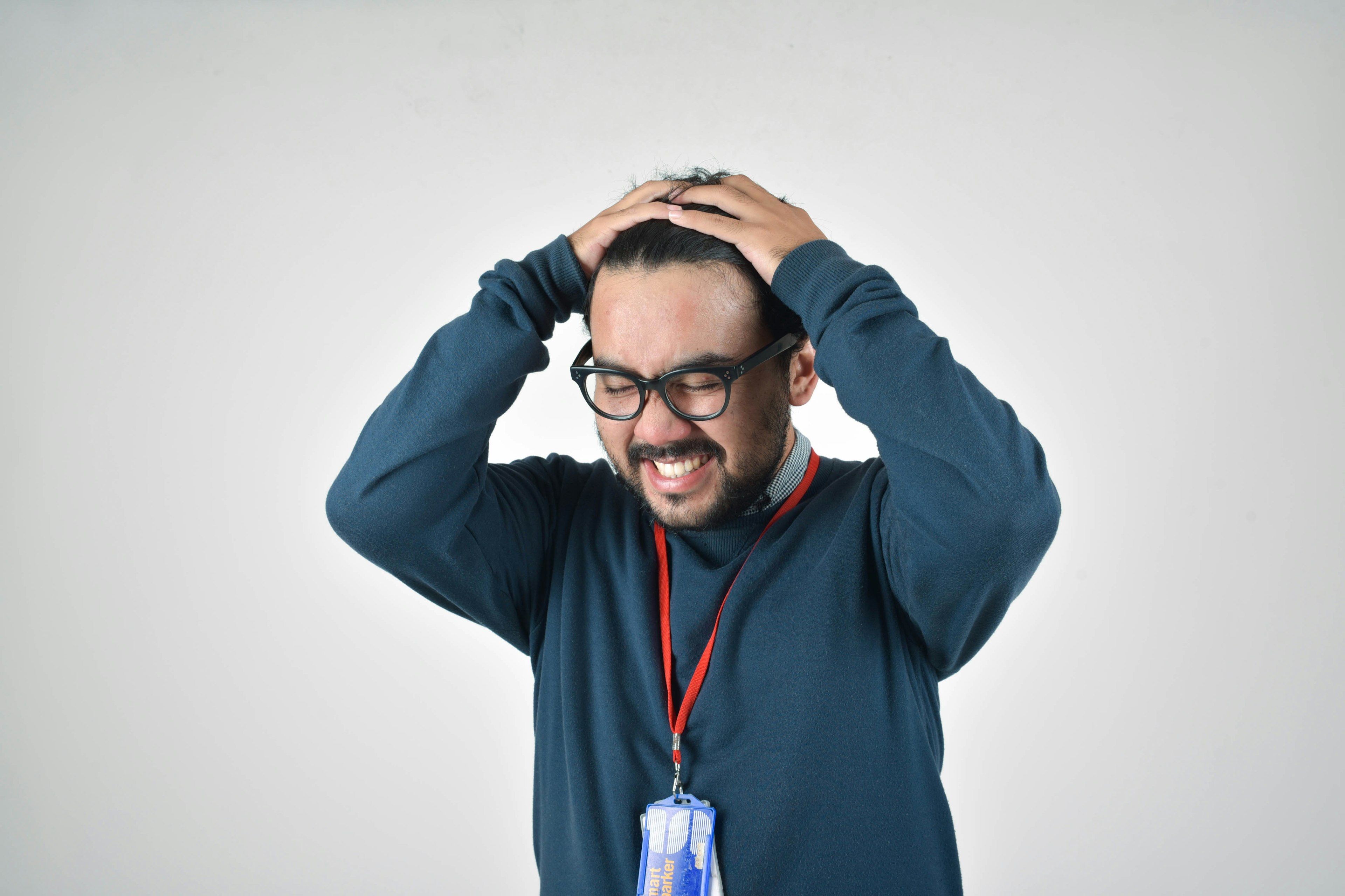 man in blue sweater showing signs of frustration