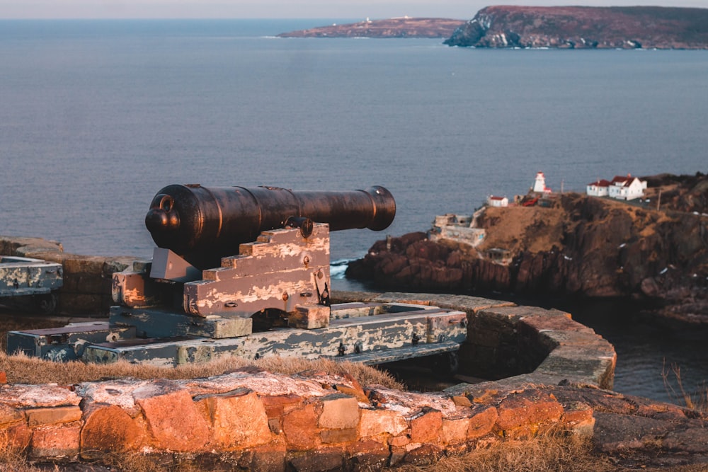 black and gray cannon statue beside brown islet