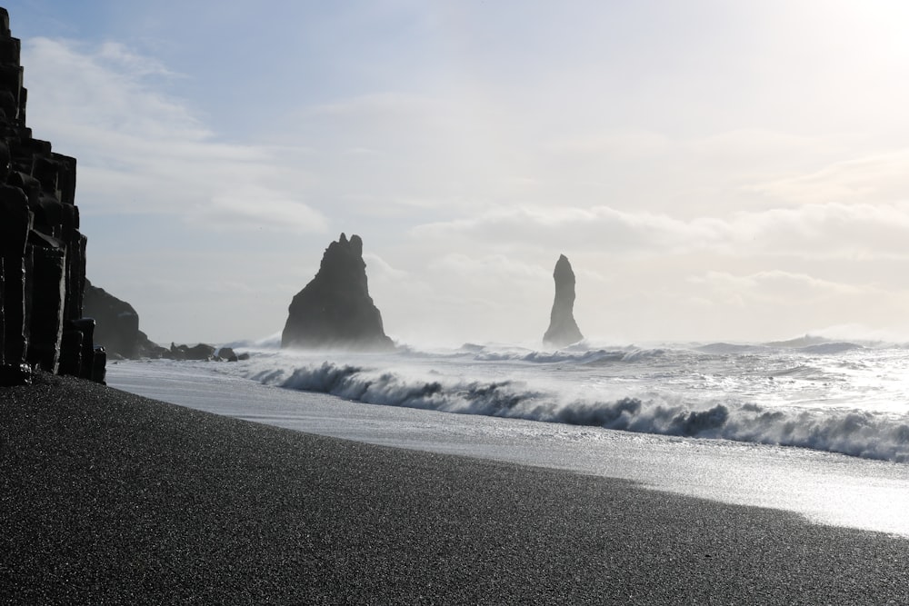 silhouette of rock formations on body of water