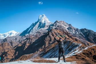 man standing by the rock formation