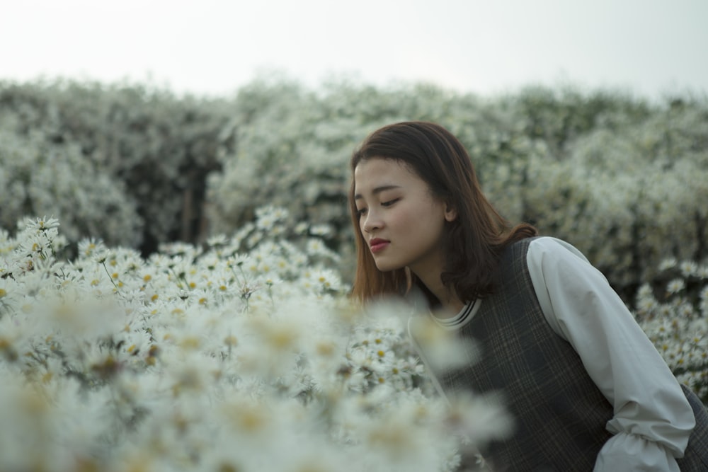 woman in white and gray long-sleeved top on flower field