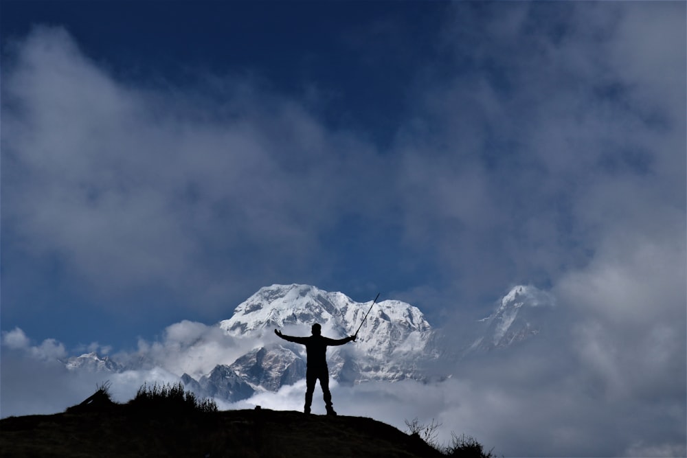 silhouette di uomo che alza entrambe le mani