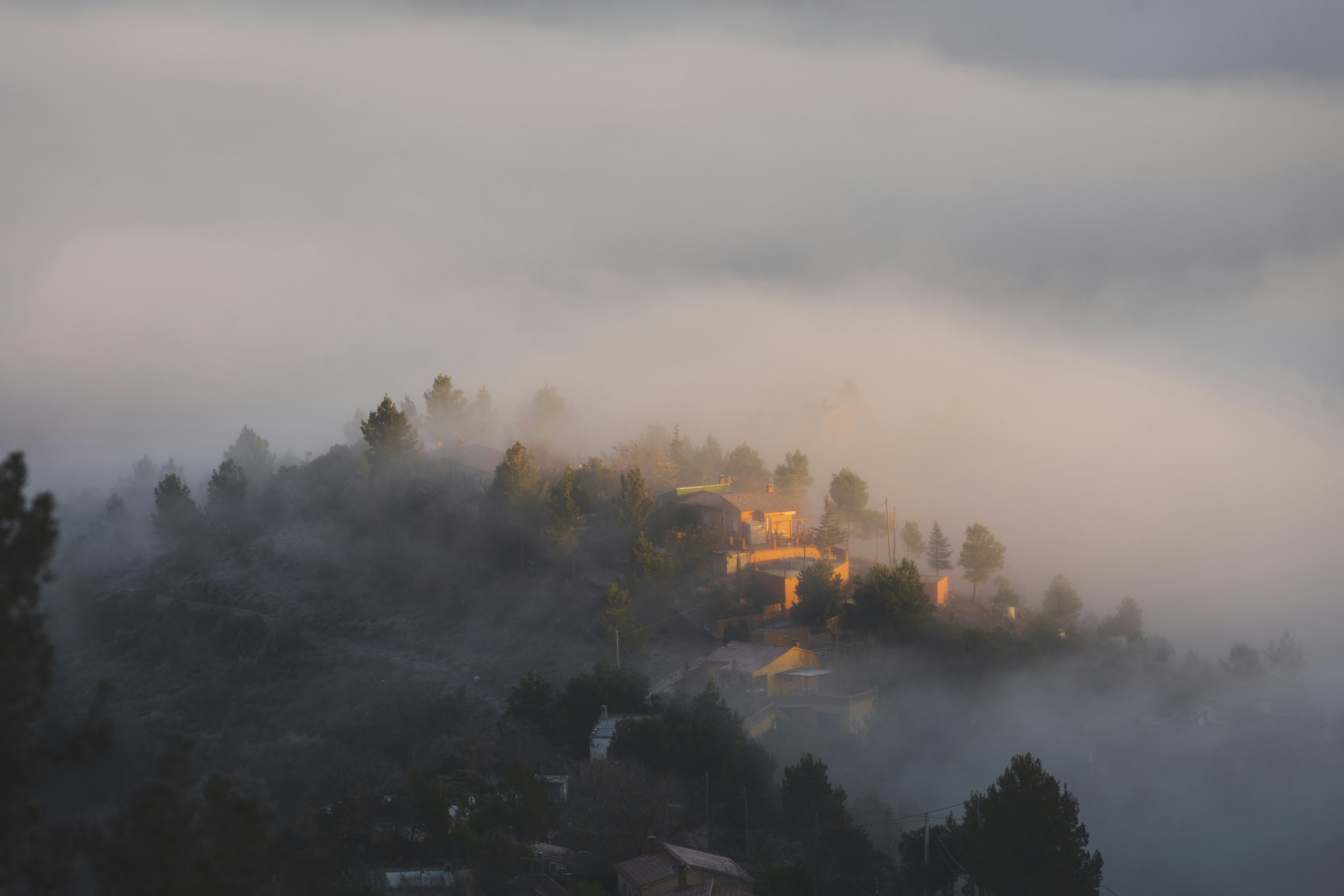 Luftaufnahme des nebelverhangenen Dorfes