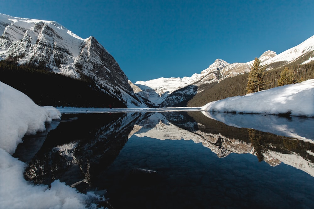 low angle photography of mountain near body of water