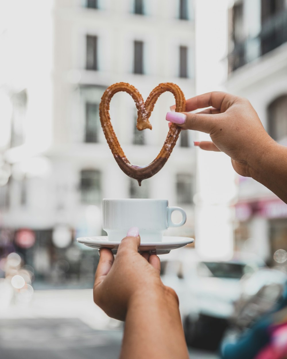 Persona sosteniendo una taza de té y churros