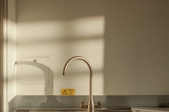 A technician installing a sleek electric water heater in a modern kitchen.
