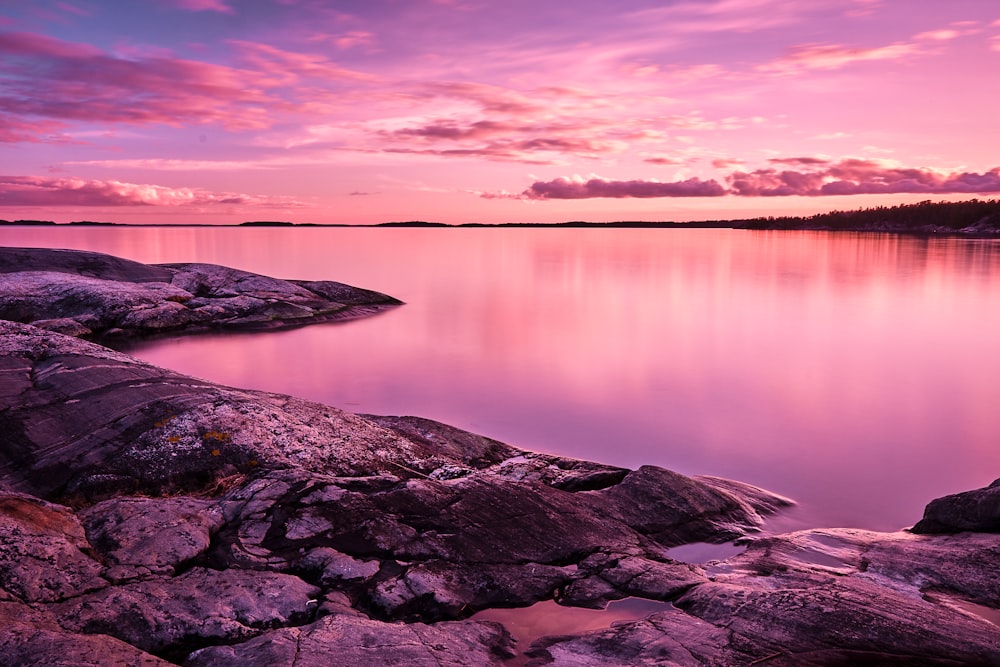 brown rock formations beside body of water