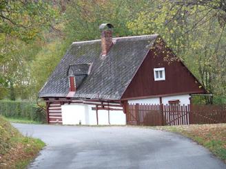 Spacious farmhouse with wraparound porch and rustic charm nestled among tall trees in a peaceful Massachusetts town.