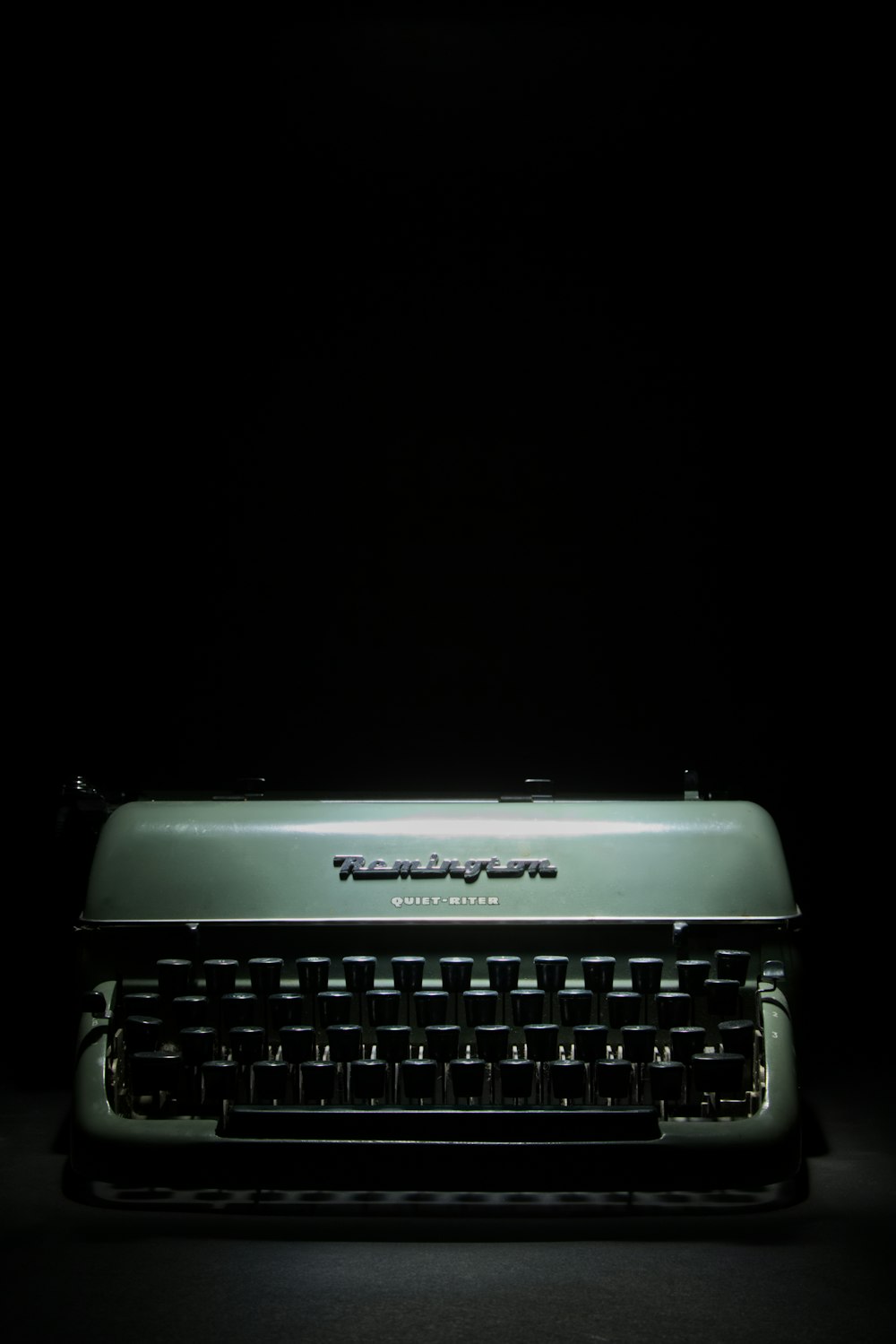 máquina de escribir gris y negra sobre fondo negro