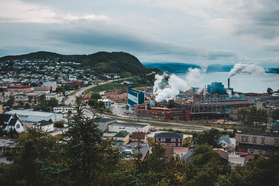 aerial photography of smoke coming from factory buildings in the city