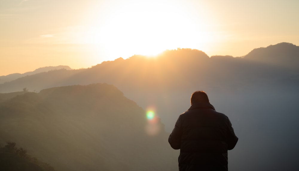 man standing facing at mountain