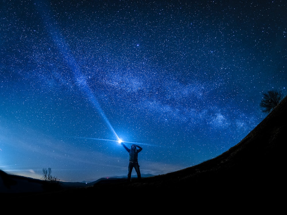 silhouette of man holding flashlight