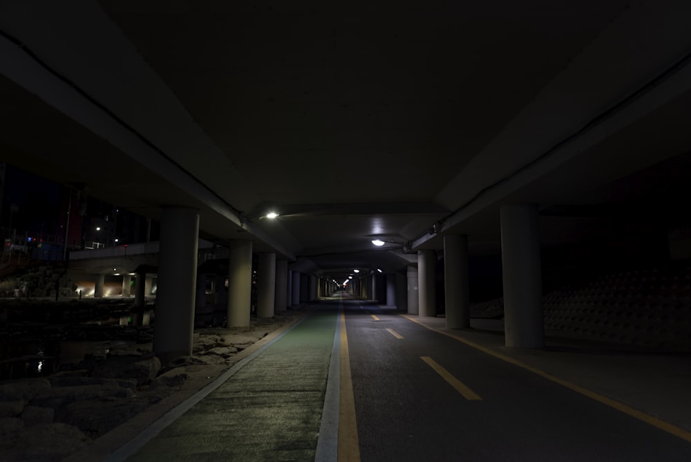 empty gray concrete pathway inside pillared building