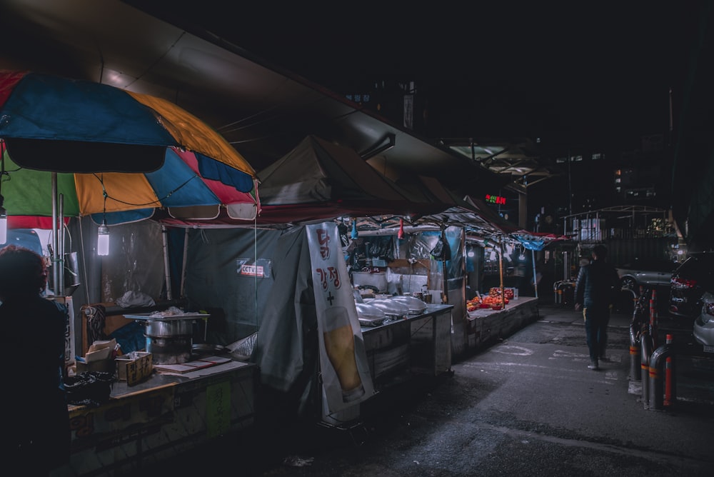 man walking along road with side walk vendors