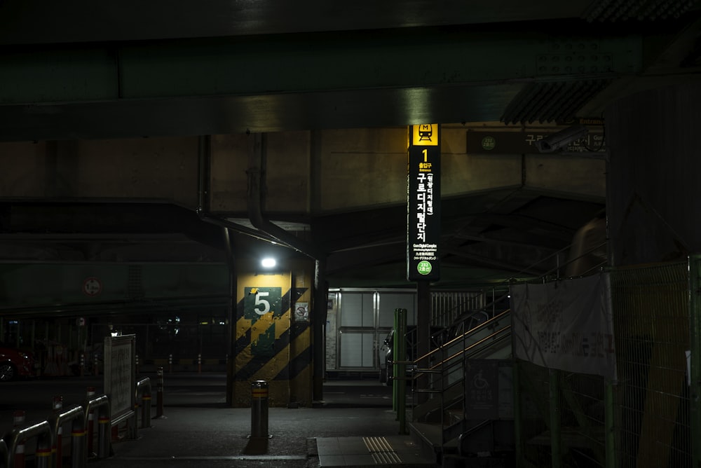 a subway station at night with a lit up sign