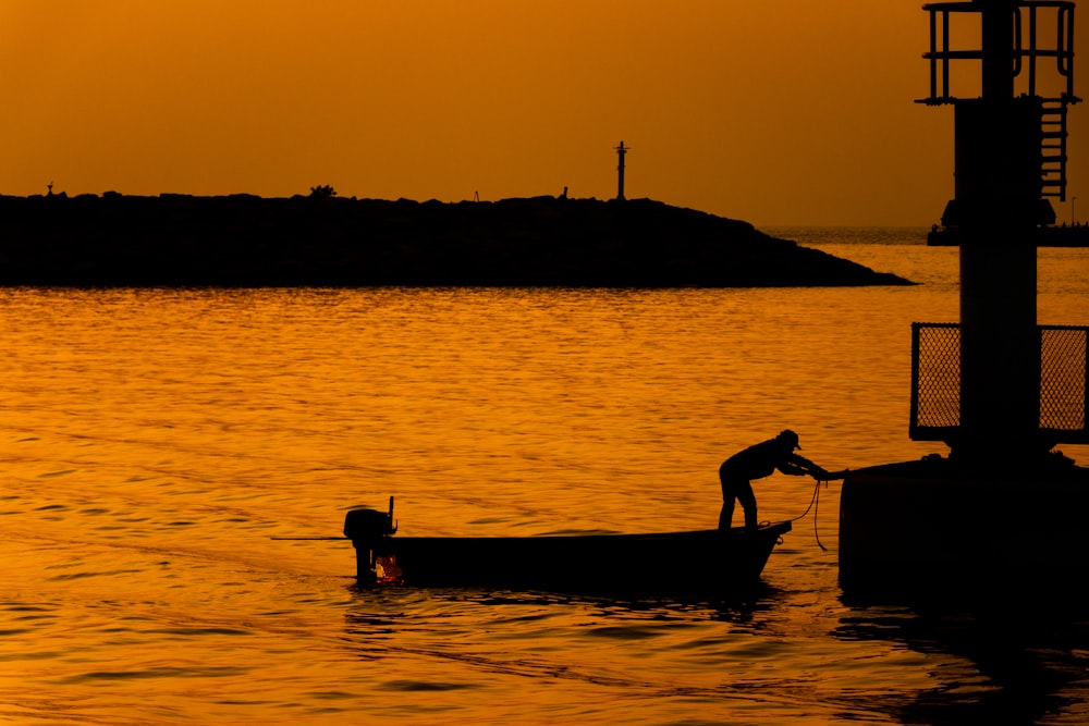 silhouette of man on boat during daytime