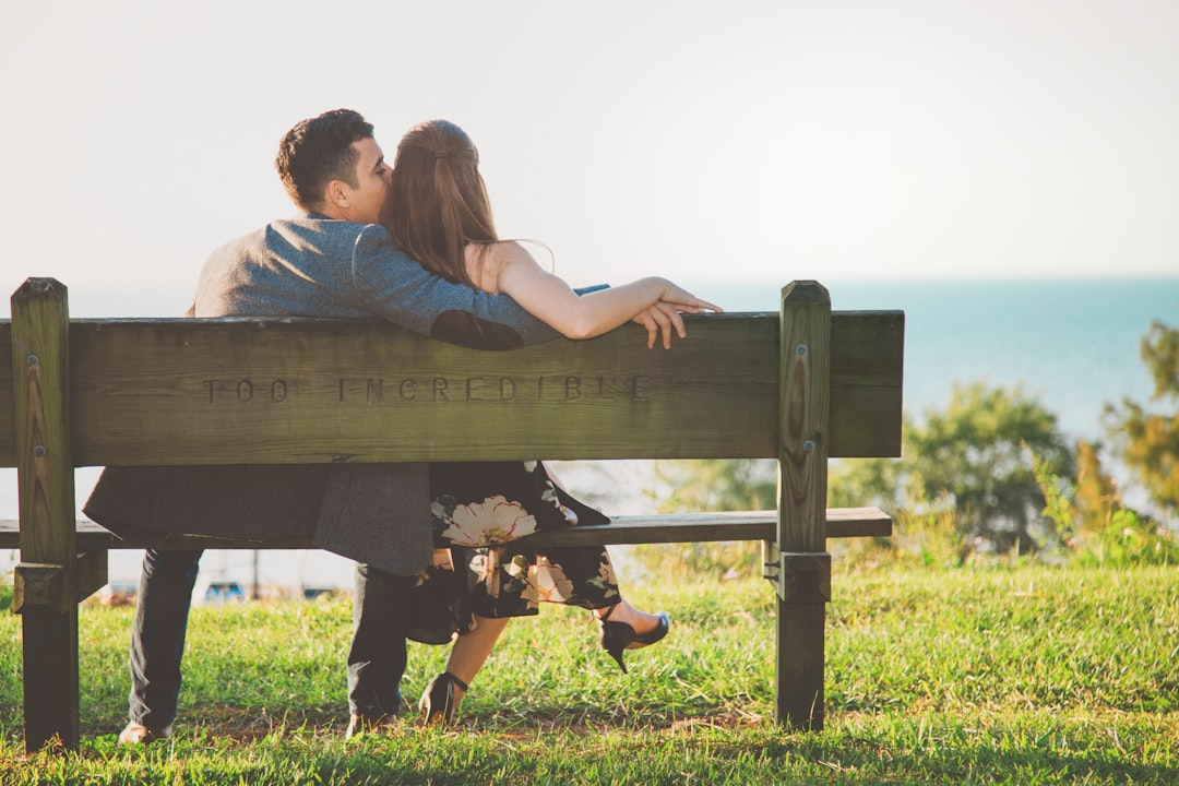 man and woman sitting on bench outdoors during daytime