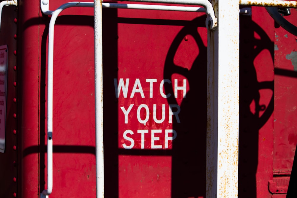 red and white watch your step-printed wall
