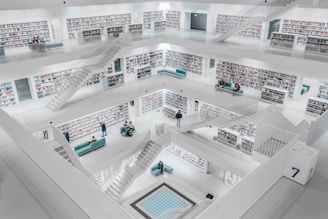 people standing inside white concrete building interior