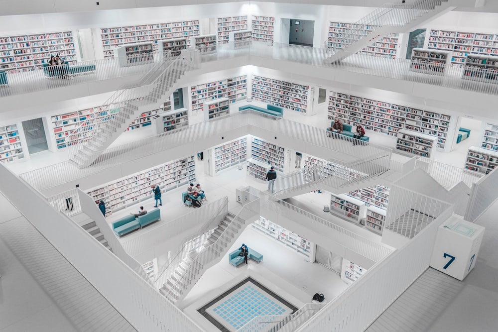 people standing inside white concrete building interior