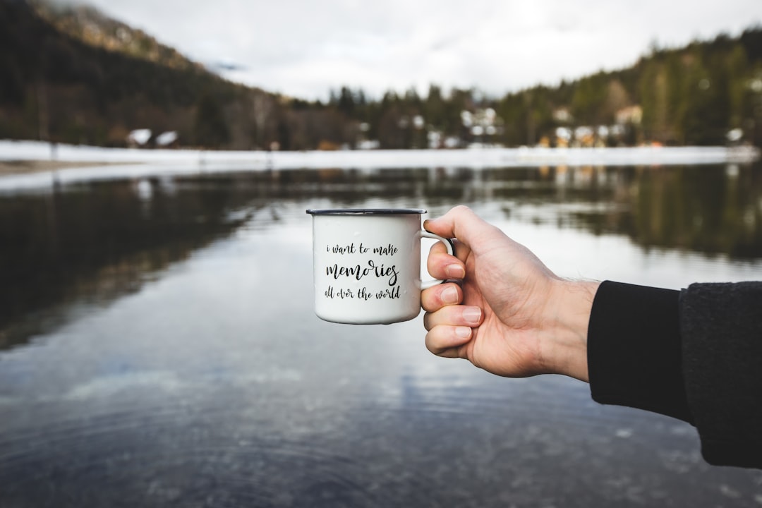 person holding white ceramic mug