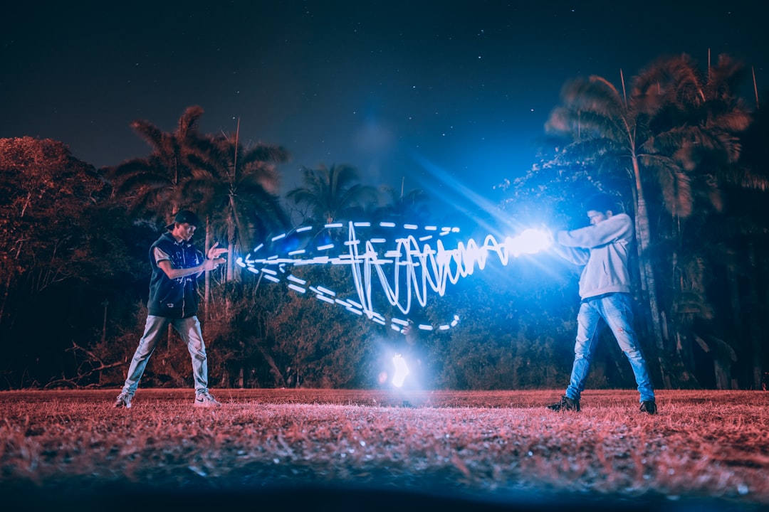 two men matching light powers at night