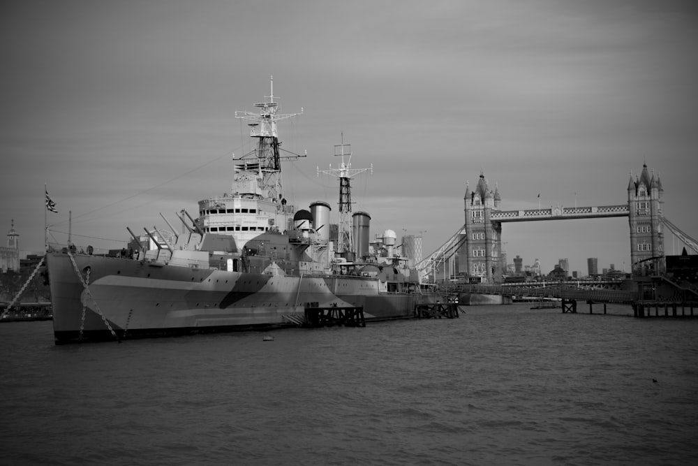 greyscale photo of ship near london bridge