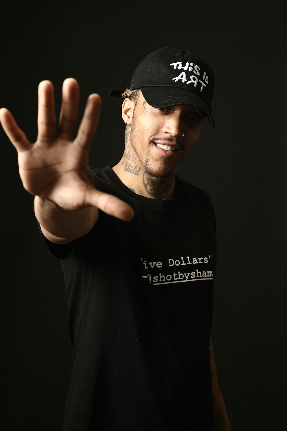 man wearing black crew-neck shirt and black fitted cap