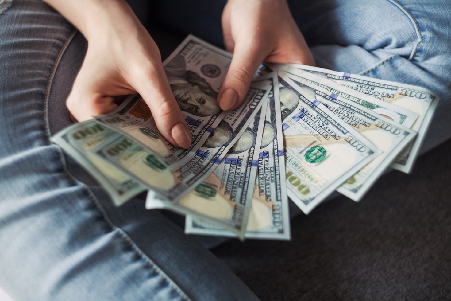  A person holding a wad of cash in their hands. 