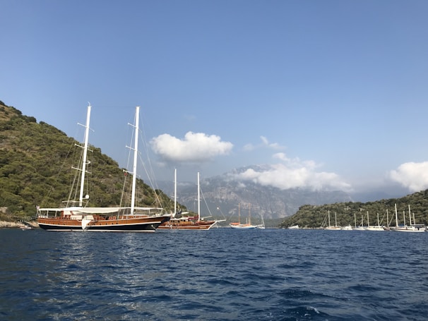 Sailboats anchored in a peaceful bay surrounded by lush green hills on Lefkada island.