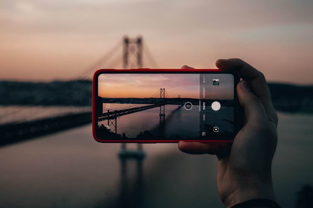 picture taken of bridge using red smartphone during sunset