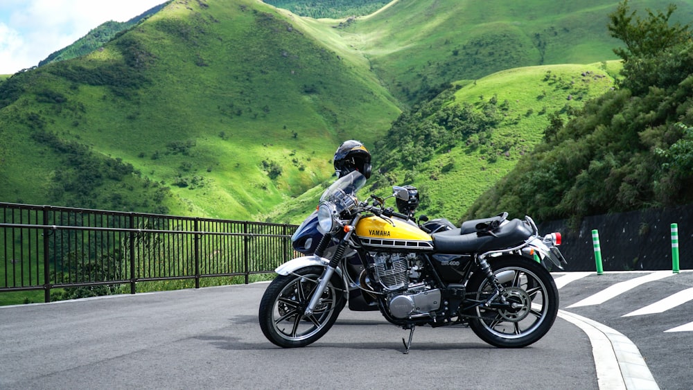 yellow and black cruiser motorcycle parking on middle of road during daytime