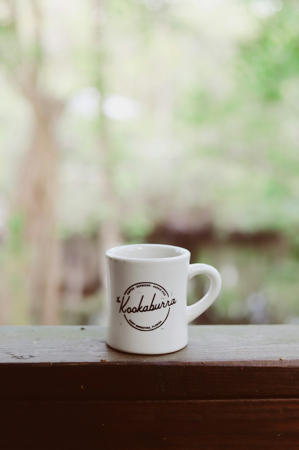 white ceramic mug on brown wooden surface