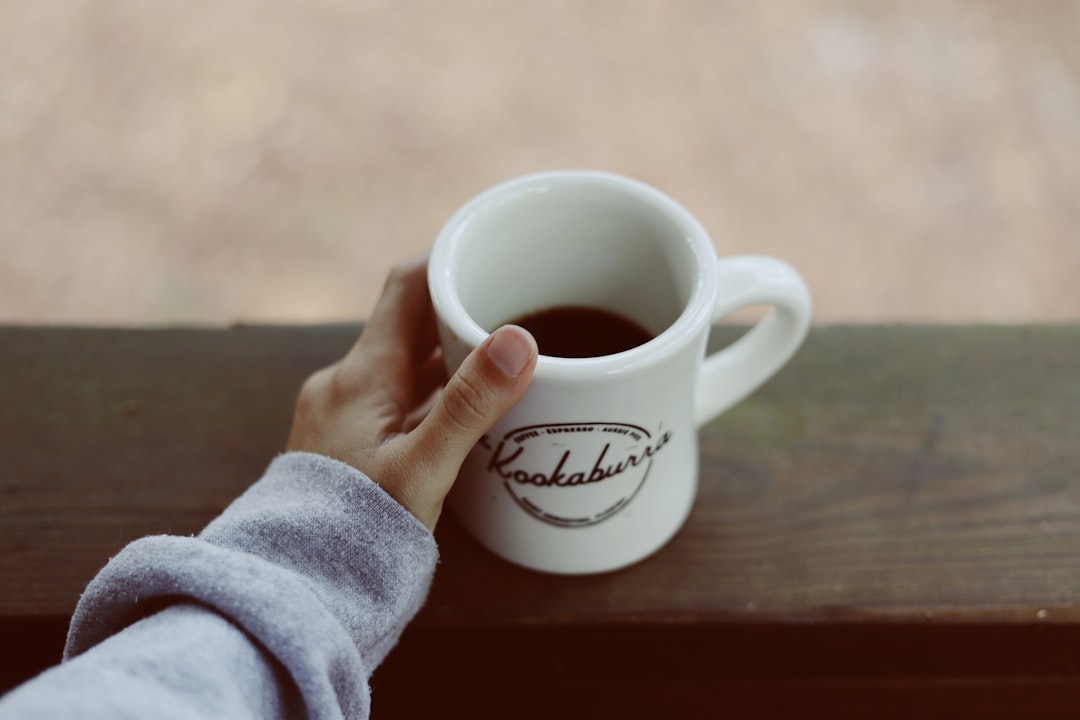 person holding white mug