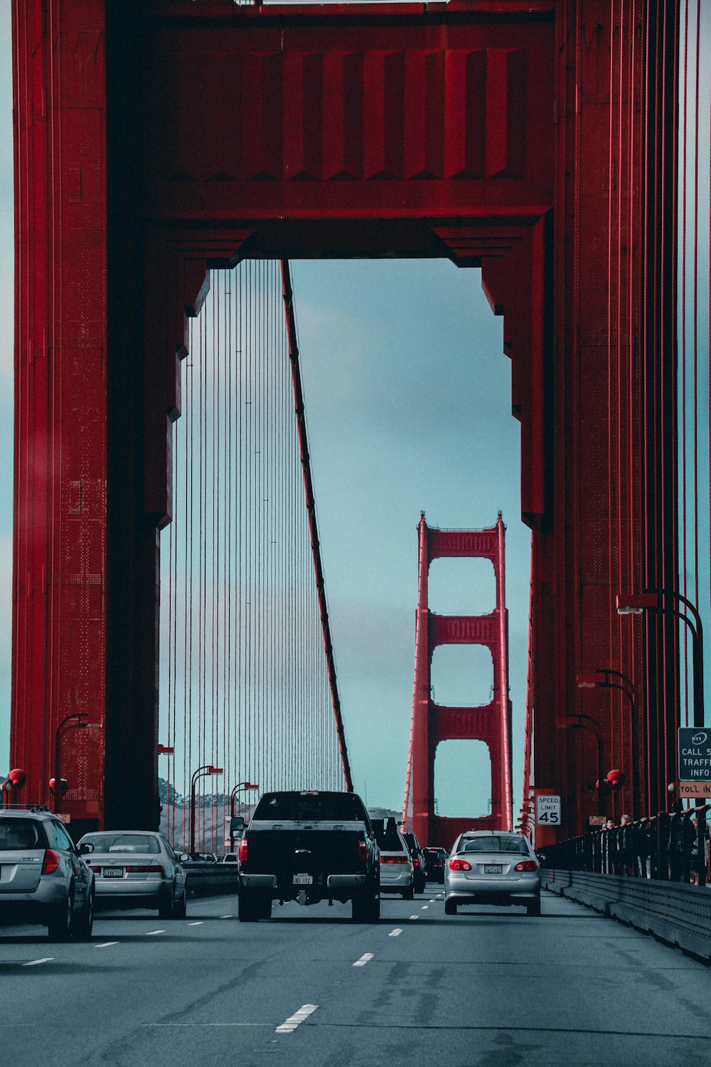 cars passing by Golden Gate Bridge during daytime