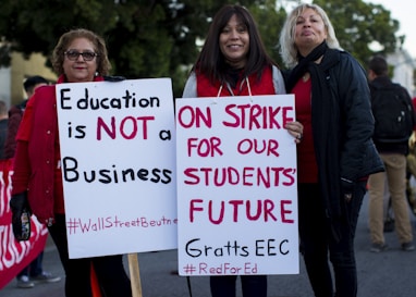three women holding signges