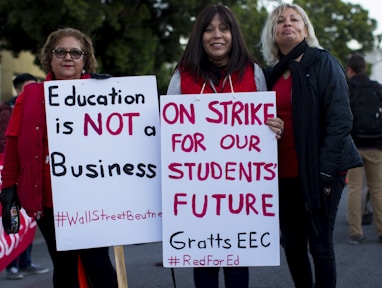 three women holding signges