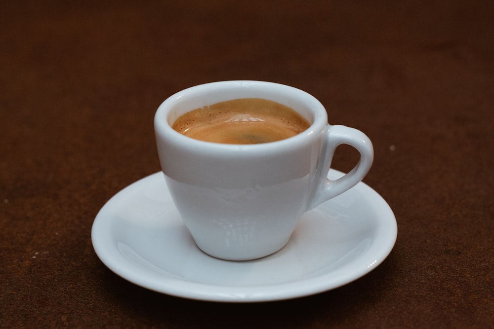 white ceramic teacup filled with brown coffee