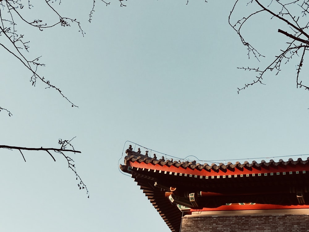 a tall building with a red roof and a tree in front of it