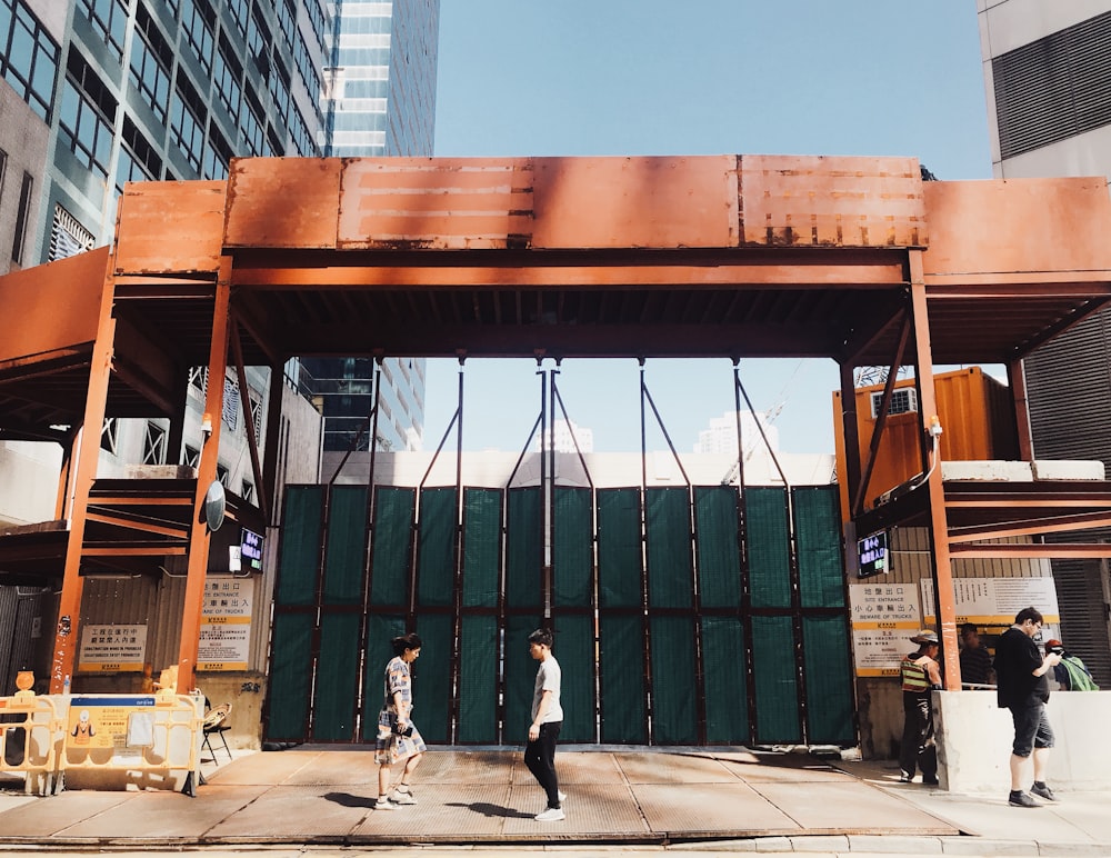 person walking in front of green steel gate