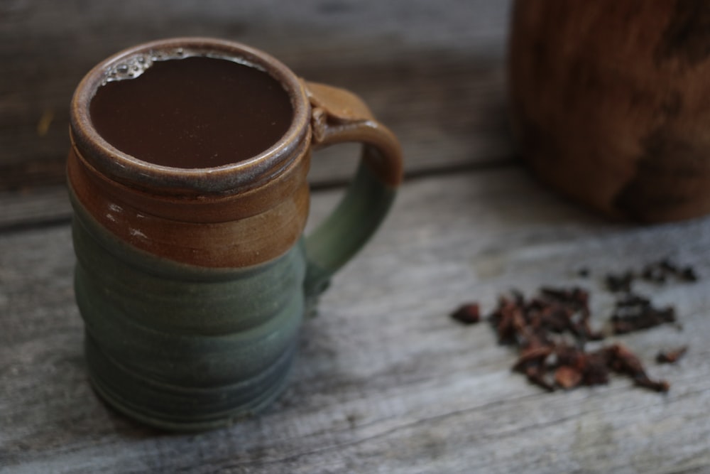green and brown mug with water