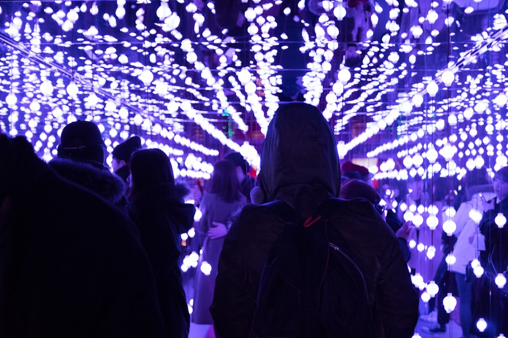 people waking under string lights