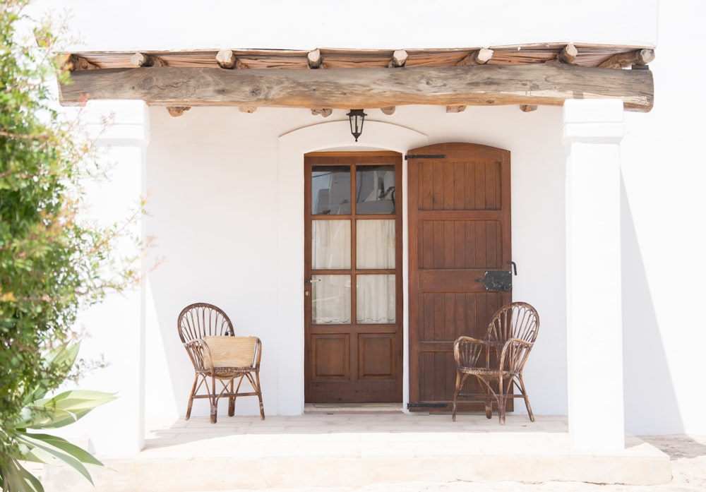 two brown rattan armchairs near door