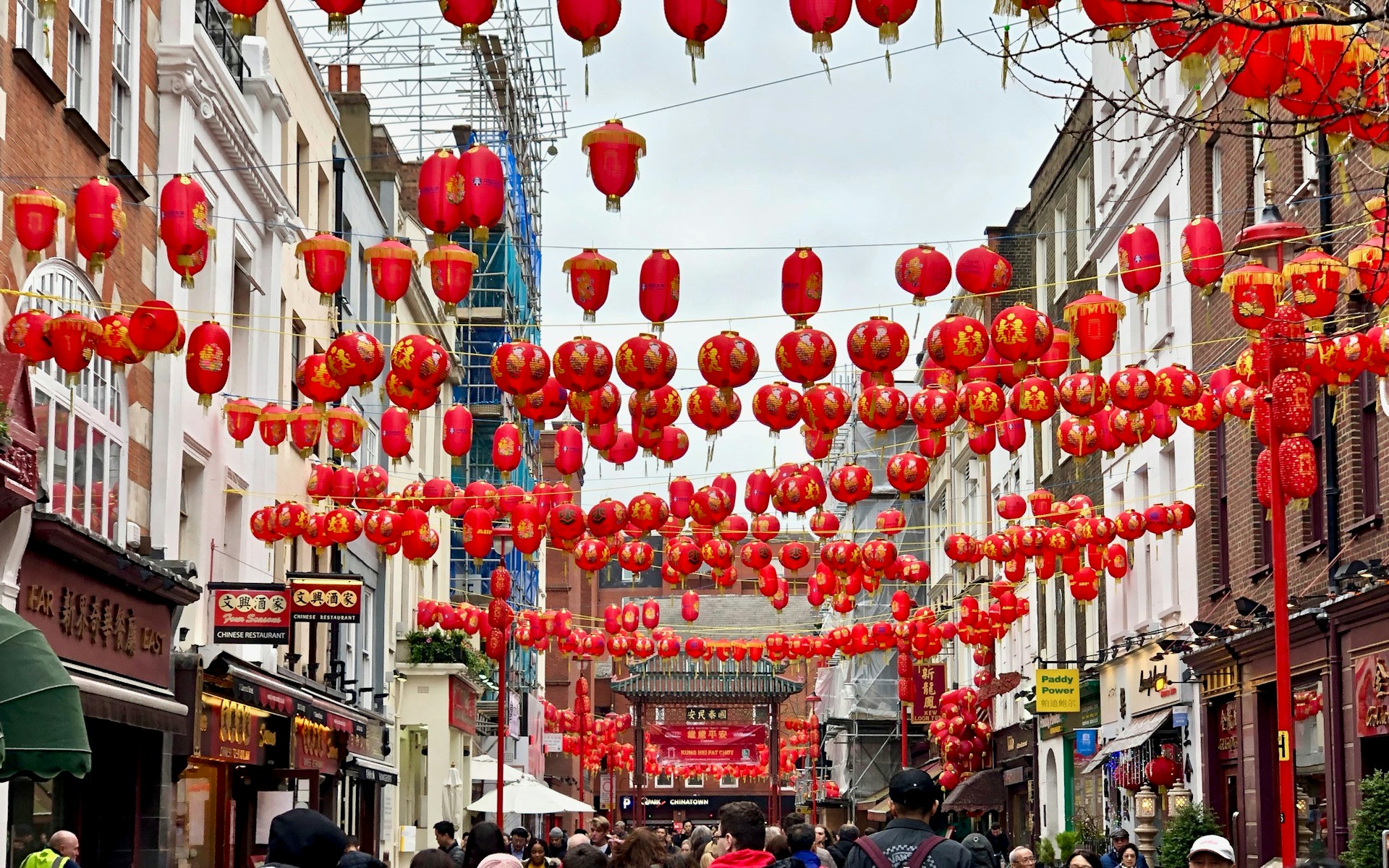 people walking under red lanterns
